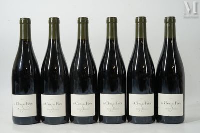 six bouteilles de vin sont alignées sur une table