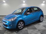 une voiture bleue est garée dans une pièce au sol à carreaux