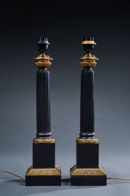 pair of black and gold candles with candlesticks on each side