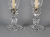 pair of clear glass candle holders with a candle on each of them
