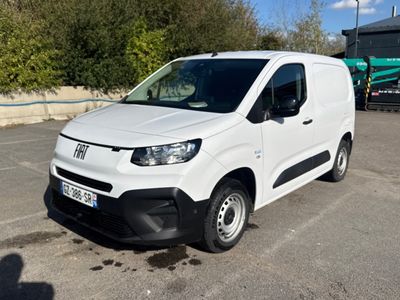 a white van parked in a parking lot with trees in the background