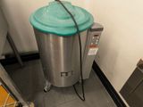 a large metal trash can with a blue lid in a kitchen