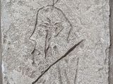 une image représentant la sculpture d'un homme tenant une lance, gravée dans la pierre