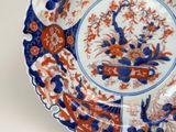 a blue and orange plate with flowers and birds on it