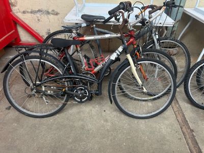 trois vélos sont garés les uns à côté des autres sur un trottoir