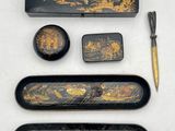 a black and gold box with a pen, pencil, and other items