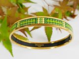 a close up of a bracelet with green squares on it