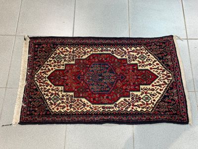 tapis posé à même le sol dans une pièce au sol carrelé de blanc