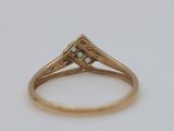 a close up of a gold ring with a green stone