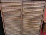une armoire surmontée de volets, dans une pièce