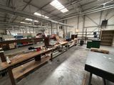 une grande salle où se trouvent de nombreuses tables et des bancs