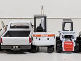 several toy trucks are lined up in a row on a white surface