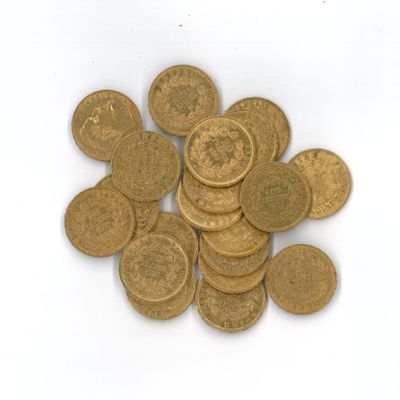 une pile de pièces d'or sur une surface blanche