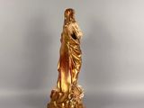 gold statue of a woman holding a child on a white surface