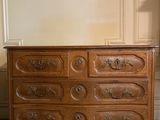 une commode en bois posée dans un coin de la pièce