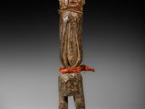 une statue en bois d'un homme avec un chapeau sur la tête