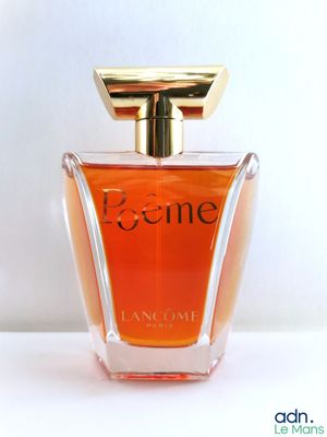 a close up of a bottle of perfume on a white surface
