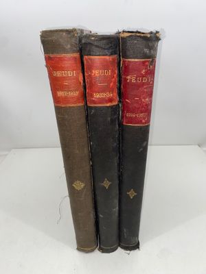 trois vieux livres posés l'un sur l'autre sur une table