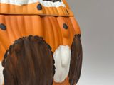 an orange and black vase with a polka dot design on it
