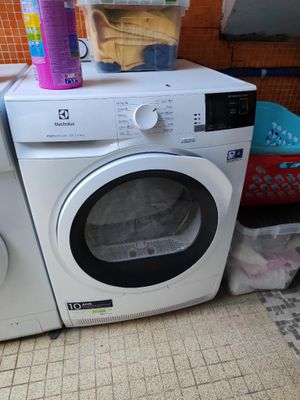 une machine à laver et un sèche-linge posés l'un à côté de l'autre sur le sol