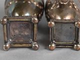 two silver salt and pepper shakers sitting next to each other