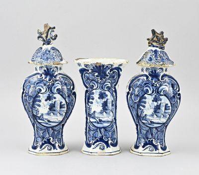 trois vases bleus et blancs surmontés d'un oiseau