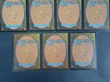 six packs of magic the gathering booster cards are on a table