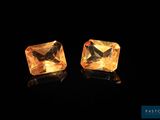 a pair of yellow sapphires on a black background