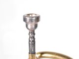 a brass trumpet that is sitting on a white surface