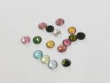 a bunch of different colored gems on a white surface