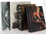 trois livres sont empilés sur une surface blanche