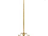 a gold floor lamp with a white shade on it
