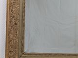 an image of a gold framed mirror on a white wall