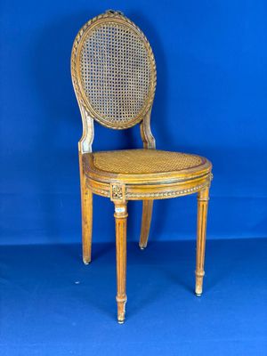 une image représentant une chaise en bois avec une assise en osier, sur fond bleu