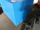 a blue box sitting on the ground next to a black hose