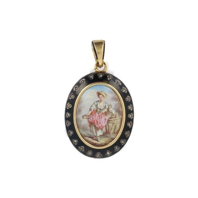 un petit pendentif noir et doré sur lequel est représentée une femme
