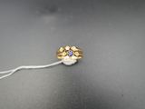 une image représentant une bague en or sertie d'un saphir beige