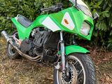 une moto verte garée dans l'herbe