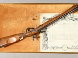 an old rifle with a wooden case and a certificate on it