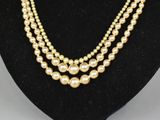 a three strand pearl necklace on a mannequin display
