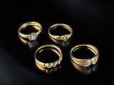 un ensemble de cinq bagues en or serties de diamants sur fond noir