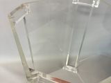 a clear glass chair that is sitting on a white surface
