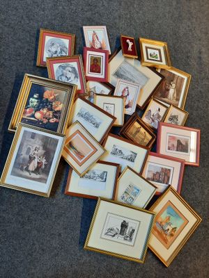 a pile of framed pictures on the floor of a room