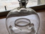 un vase en verre muni d'un couvercle en verre, posé sur une table
