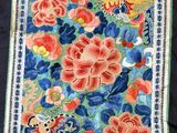 a close up of a green cloth with flowers and birds on it