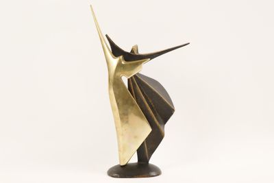 an abstract bronze sculpture of a man with a hat on his head