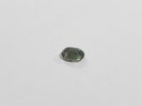 a green tourmaline stone on a white surface