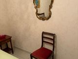 a bed and a chair in a room with a mirror on the wall