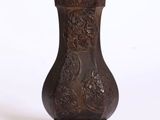 un vase marron posé sur un socle, sur une surface blanche