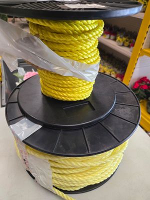 une bobine de corde jaune posée sur une bobine noire